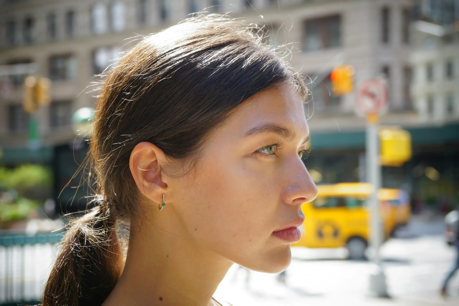 Mujer joven de perfil con el pelo recogido y la frente despejada, con luz natural